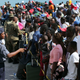 A Bahama’s Army officer speaks with people evacuated prior boarding a ferry to Nassau at the Port in Marsh Harbor, Abaco Island, Bahamas, Saturday, Sept. 7, 2019.